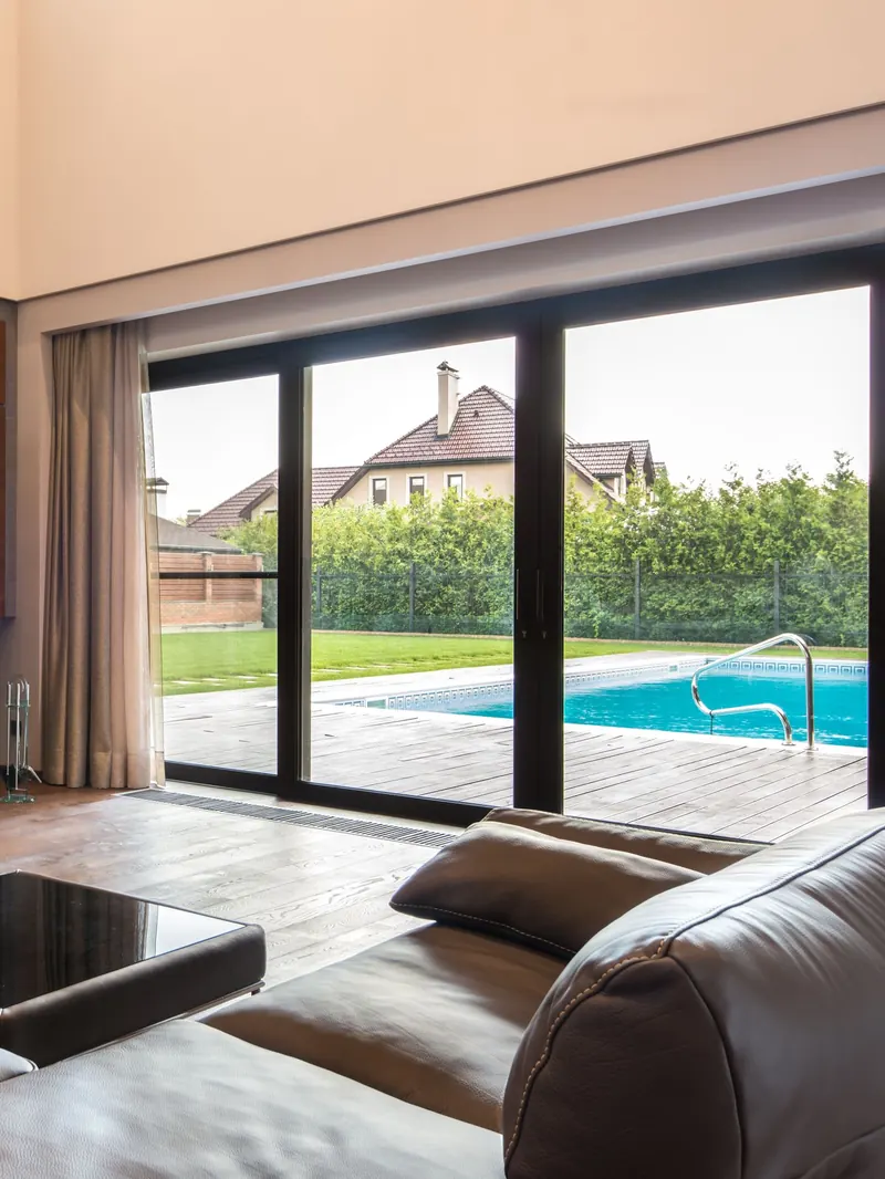Zwarte aluminium schuifpui, deels geopend naar het terras